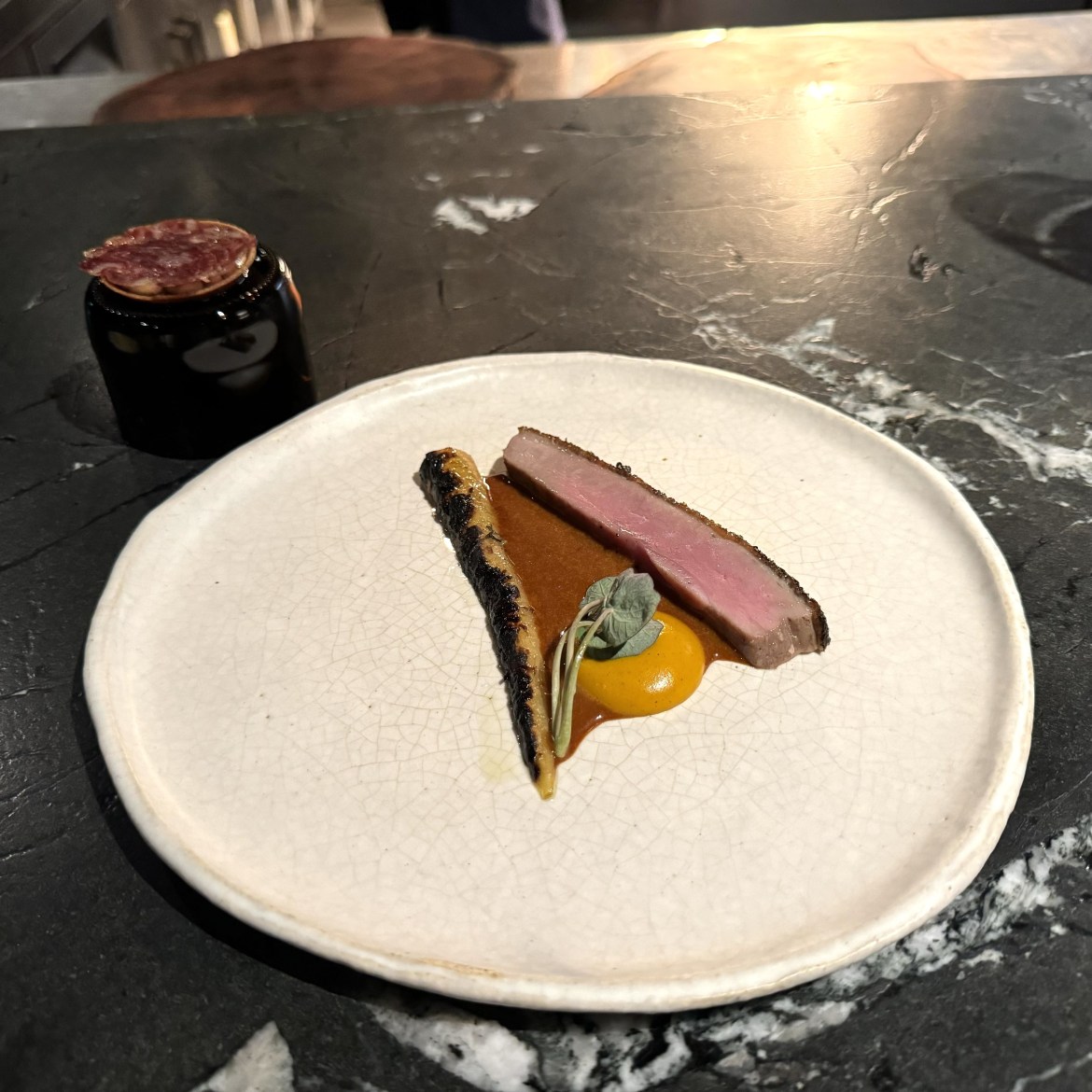 Duck and carrot on a white plate with salami.