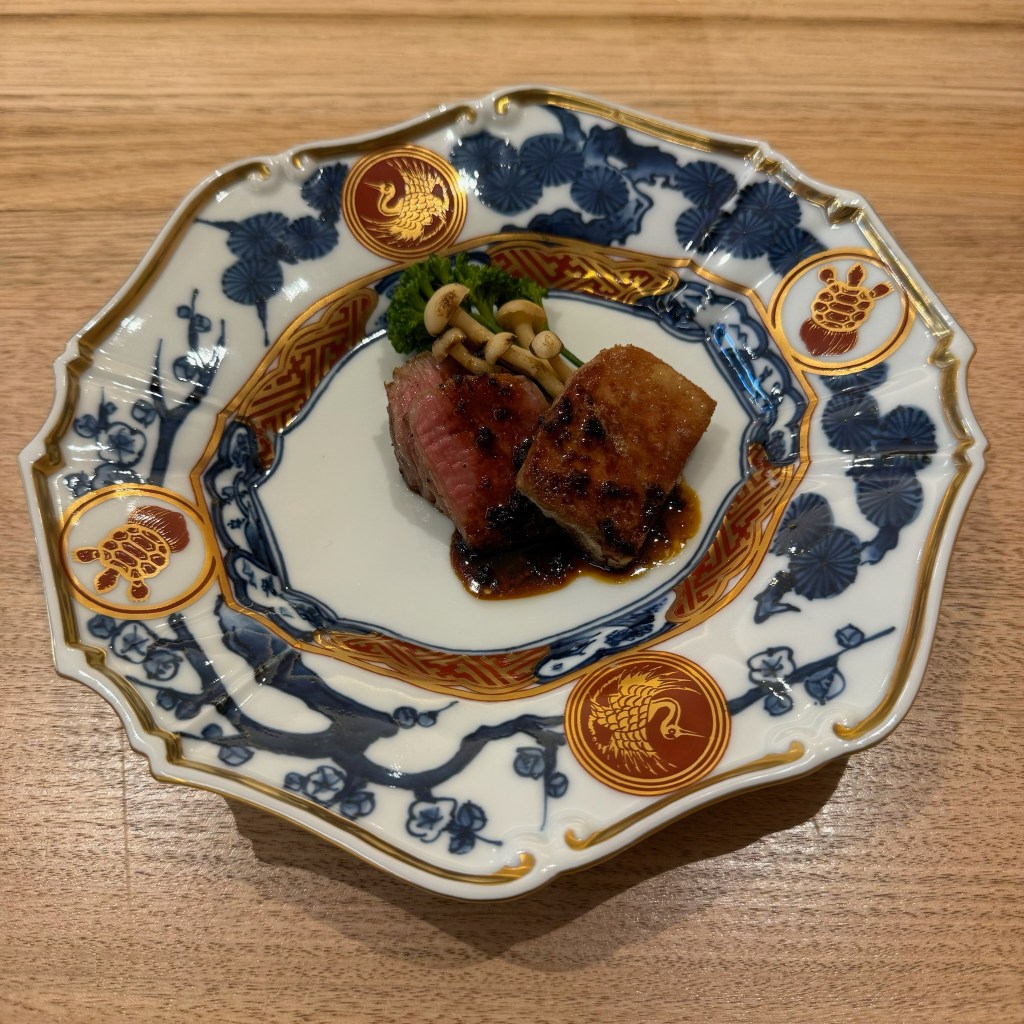 Wagyu beef with sauce on a patterned plate at Tsuzumi Omakase.